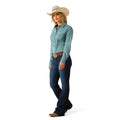 Woman wearing a light blue shirt, dark blue jeans, and a beige cowboy hat on a white background