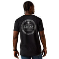 Person wearing a black t-shirt with Ariat branding on the back, standing against a white background