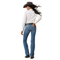 Woman wearing a white shirt, blue jeans, and a brown cowboy hat on a white background