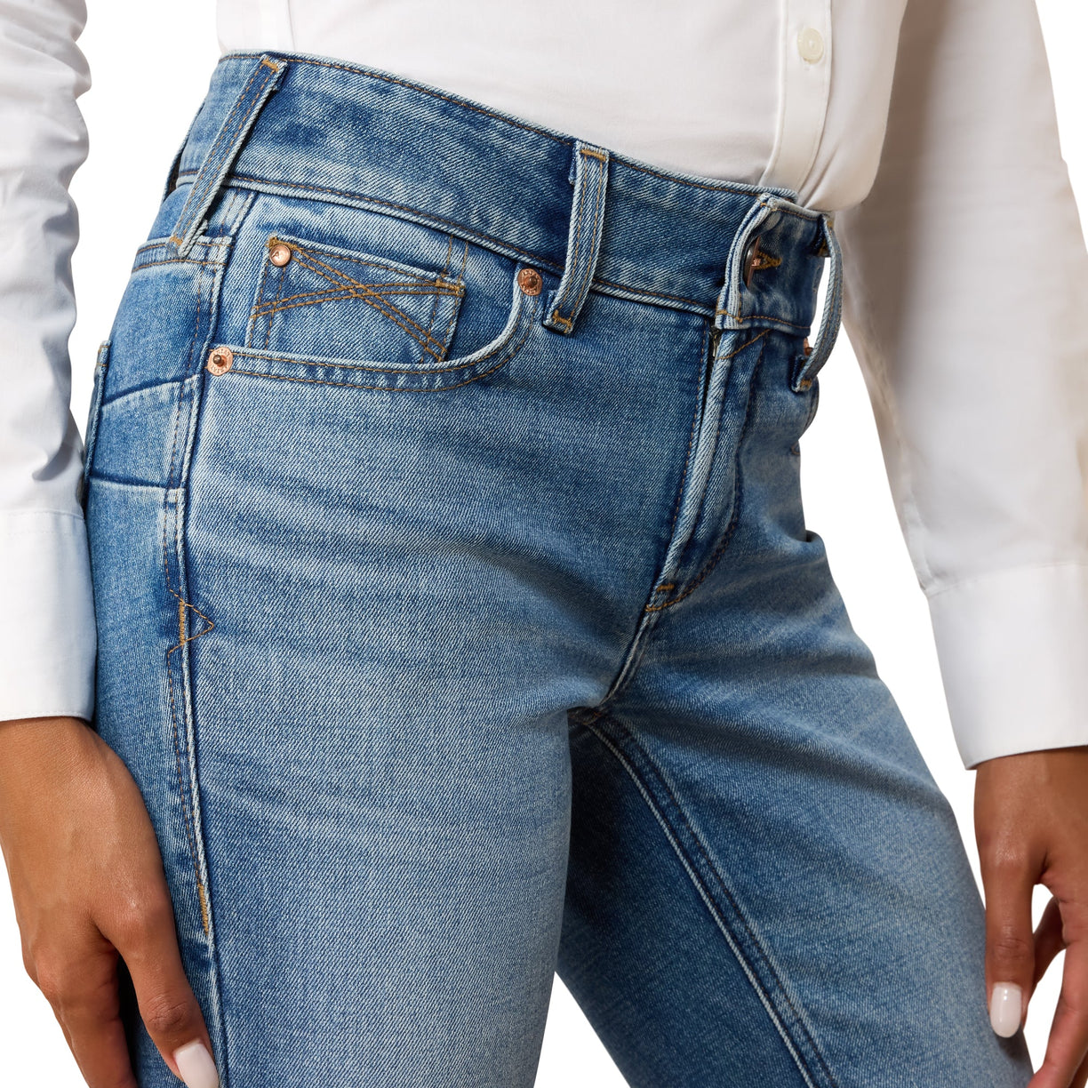 Close-up of blue jeans worn by a person with a white shirt.