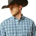 Man wearing a blue plaid shirt and cowboy hat on a white background