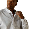 Man wearing a patterned shirt with a visible brand logo on a white background