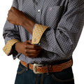 Person wearing a patterned shirt with rolled-up sleeves and a belt, on a white background