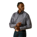 Man wearing a patterned shirt and dark pants on a white background