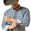 Man wearing a plaid shirt with rolled-up sleeves and a cowboy hat on a white background