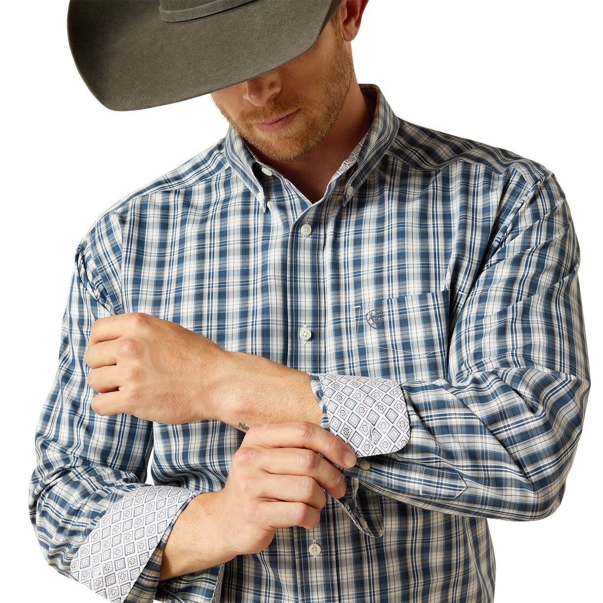 Man wearing a plaid shirt with rolled-up sleeves and a cowboy hat on a white background