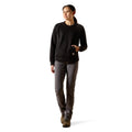 Person wearing a black sweater and gray pants on a white background