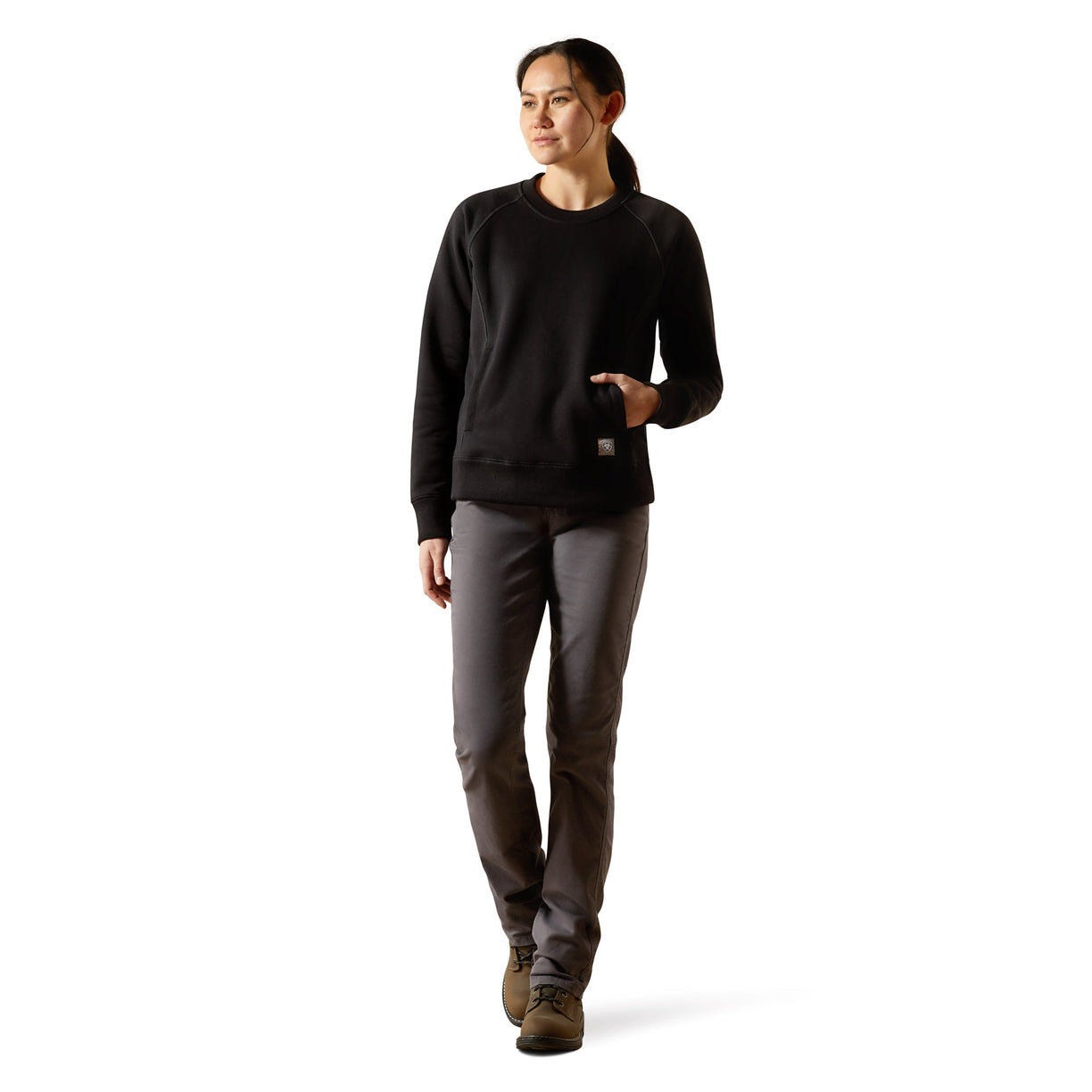 Person wearing a black sweater and gray pants on a white background