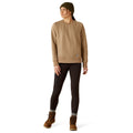 Person wearing a beige sweatshirt, dark pants, and brown boots on a white background