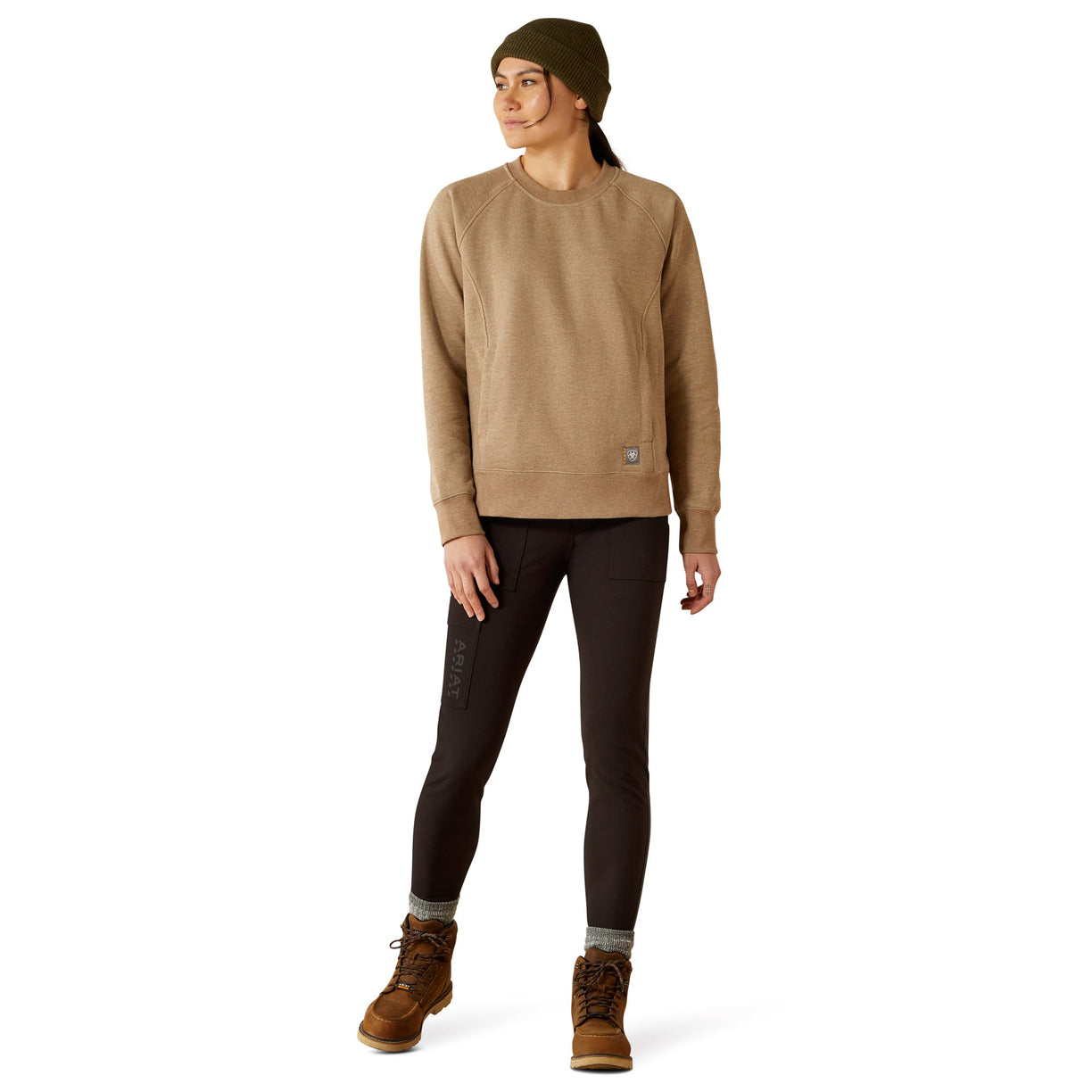 Person wearing a beige sweatshirt, dark pants, and brown boots on a white background