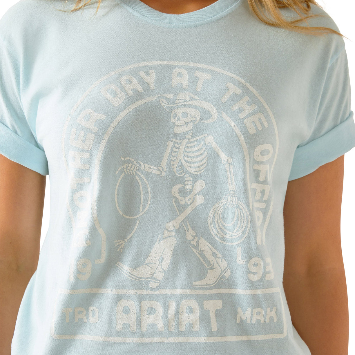 Light blue t-shirt with skeleton graphic and text on a person wearing it.