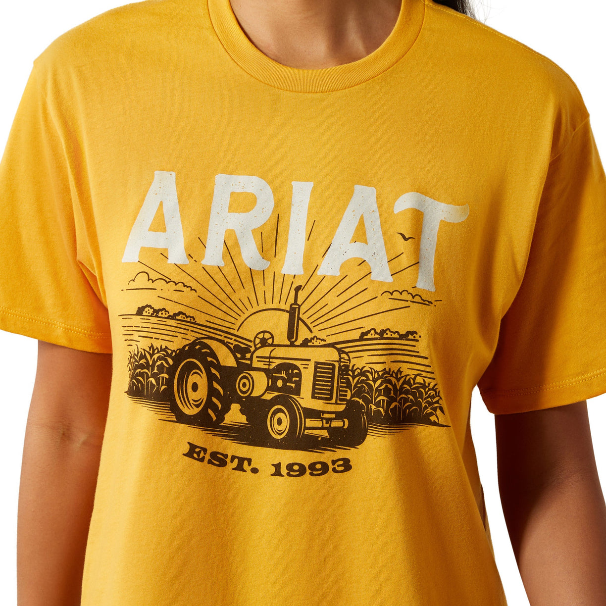 Yellow t-shirt with Ariat logo and tractor graphic on a white background