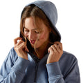 Woman wearing a blue hoodie with the hood up on a white background