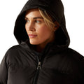 Woman wearing a black hooded jacket on a white background