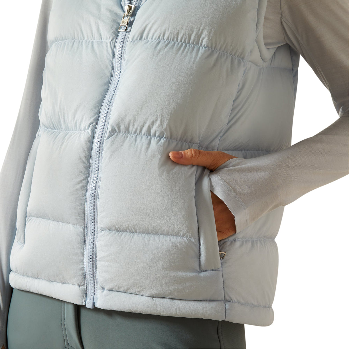 Light gray puffer vest worn by a person on a white background