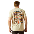 Man wearing a beige t-shirt with a colorful geometric pattern and 'B Ariat' branding on the back.