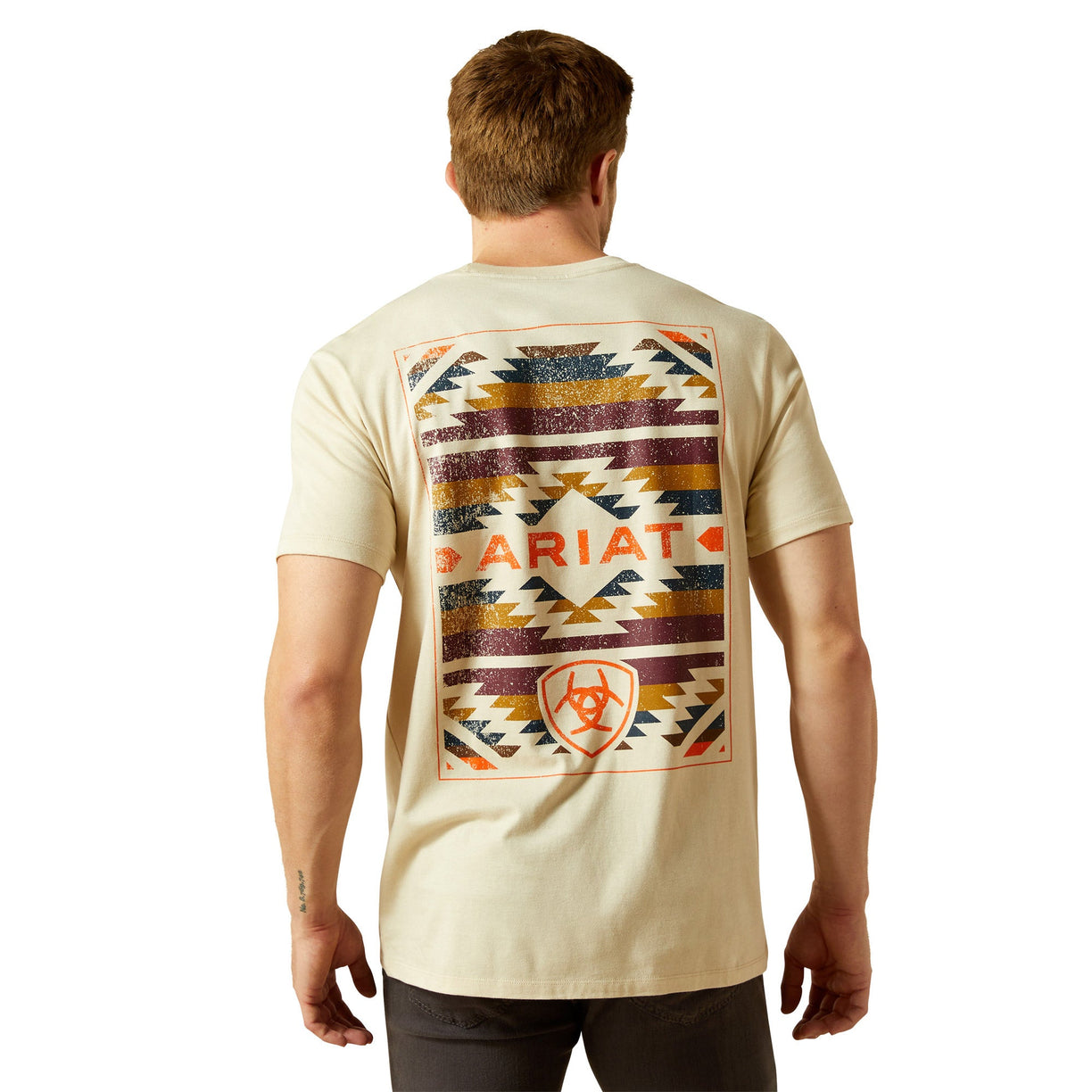 Man wearing a beige t-shirt with a colorful geometric pattern and 'B Ariat' branding on the back.