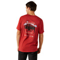 Man wearing a red Ariat t-shirt with a graphic design on the back.