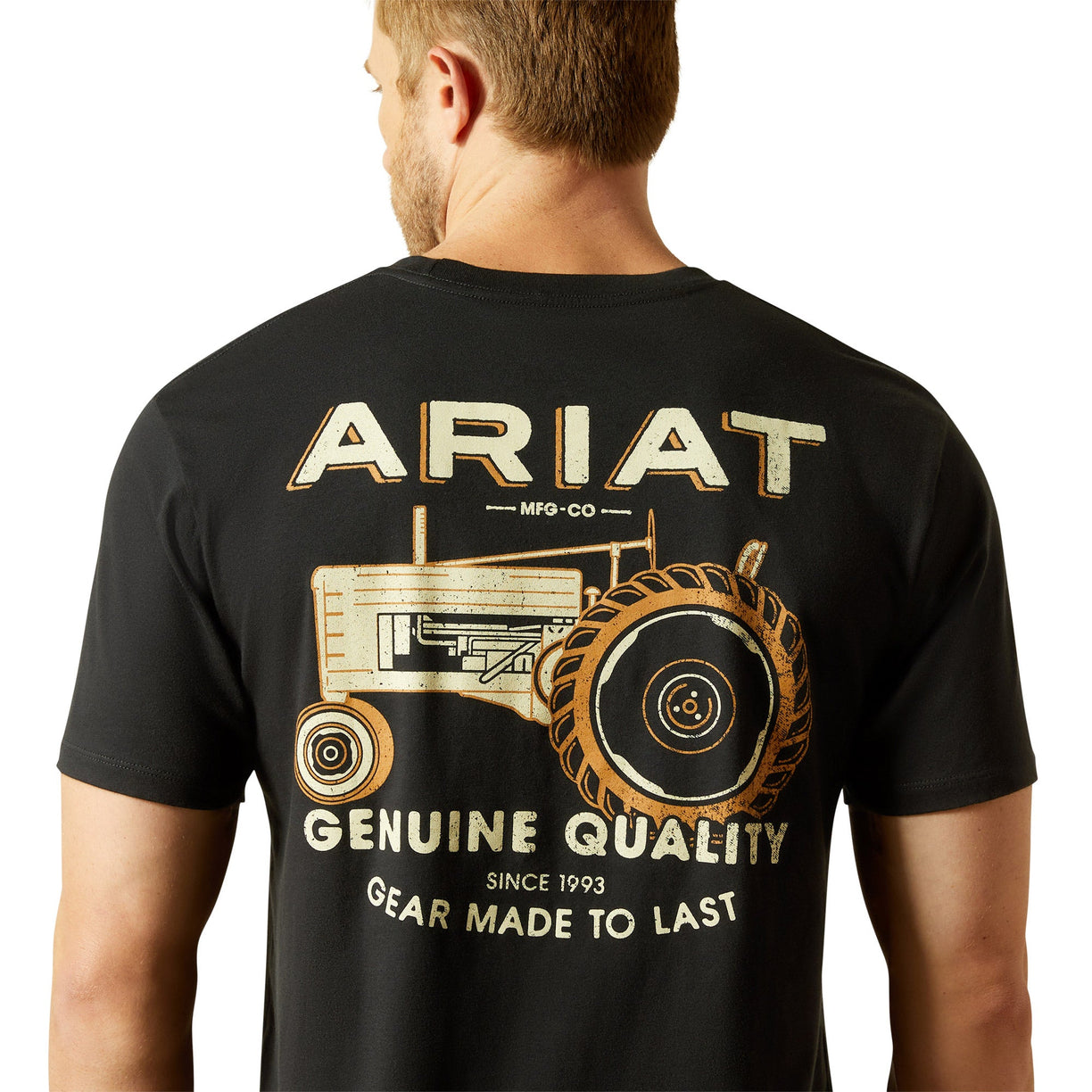 Man wearing a black t-shirt with Ariat branding and tractor graphic on the back.