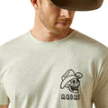 Man wearing a light gray t-shirt with a skull and hat graphic and 'Ariat' branding.
