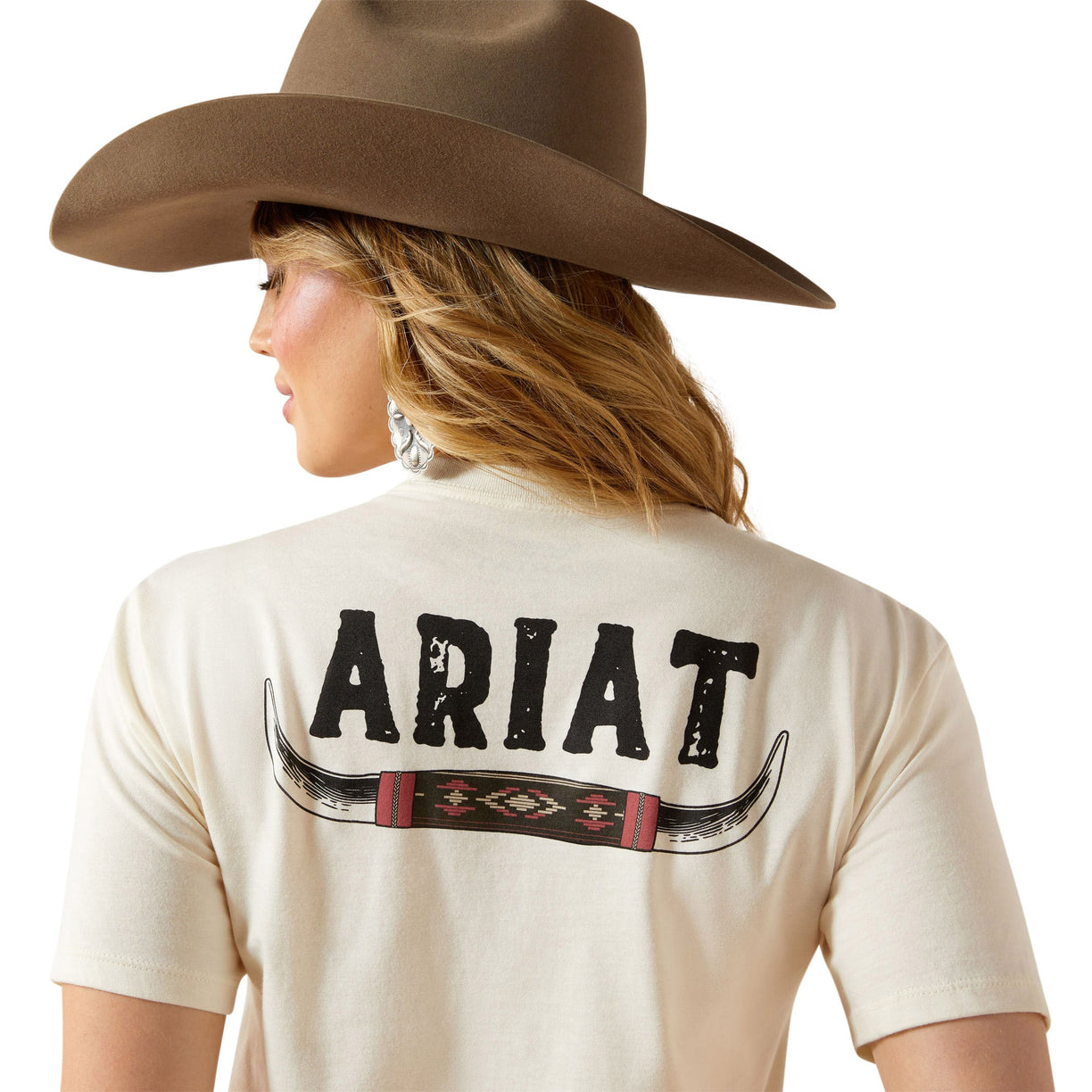 Person wearing a beige shirt with 'Ariat' branding and a brown cowboy hat on a white background