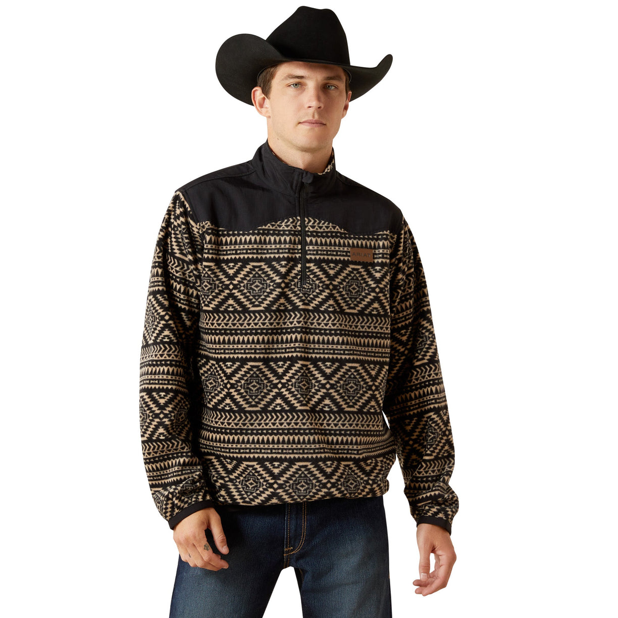 Man wearing a black and brown patterned pullover with a cowboy hat on a white background