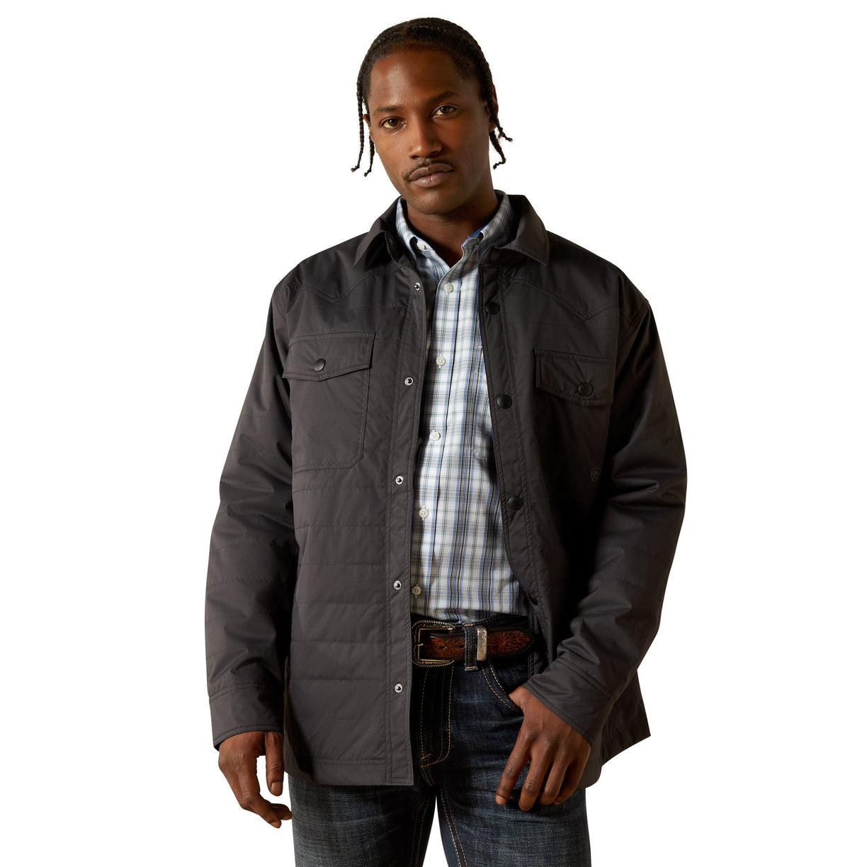 Man wearing a dark jacket over a plaid shirt on a white background