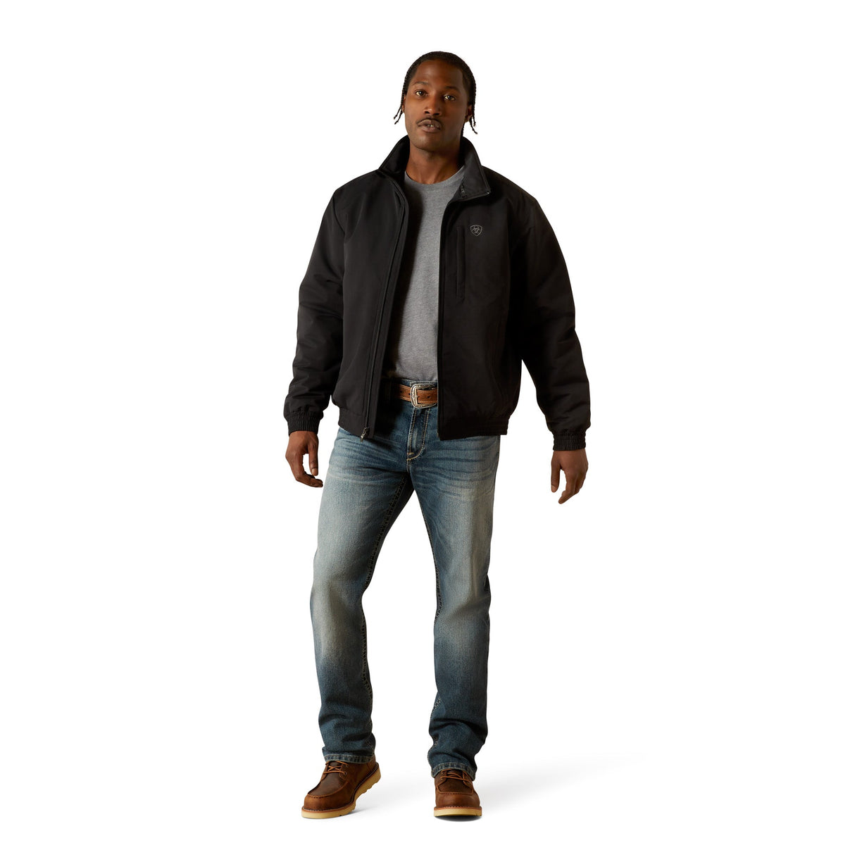 Man wearing a black jacket, gray shirt, blue jeans, and brown boots on a white background