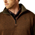 Close-up of a brown pullover with a collar and logo on a white background