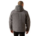 Person wearing a gray quilted jacket on a white background