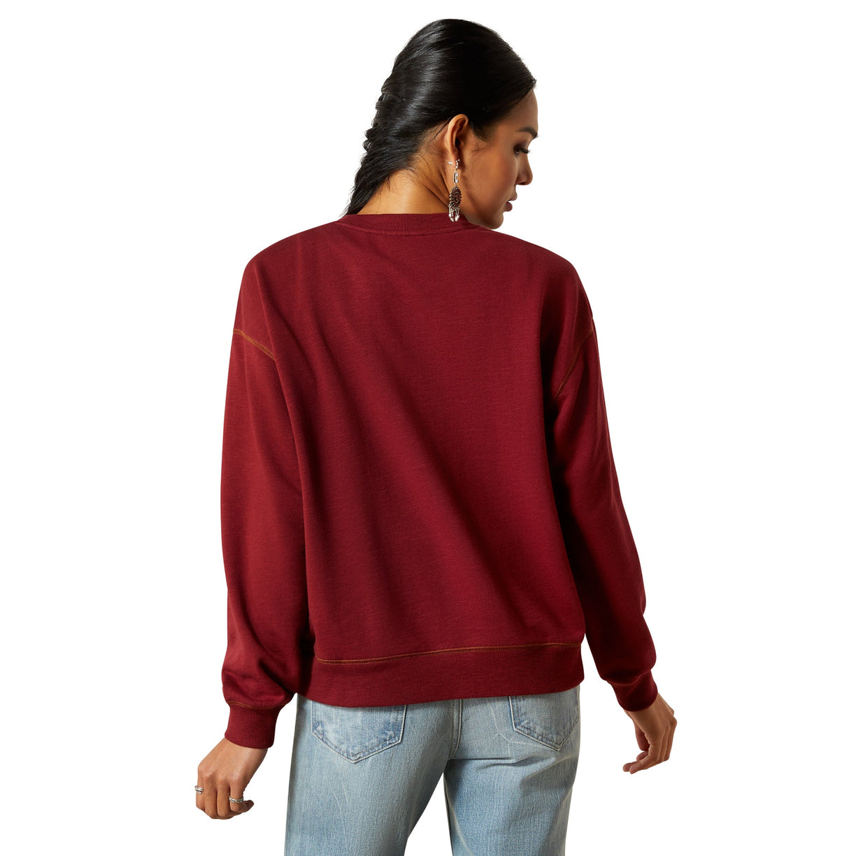 Person wearing a red sweatshirt and light blue jeans on a white background