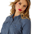 Woman wearing a blue shirt with a plain background