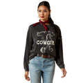 Woman wearing a black sweatshirt with 'Always in my Cowgirl Era' text and graphic, paired with blue jeans on a white background.