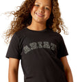 Child wearing a black t-shirt with white text on a white background