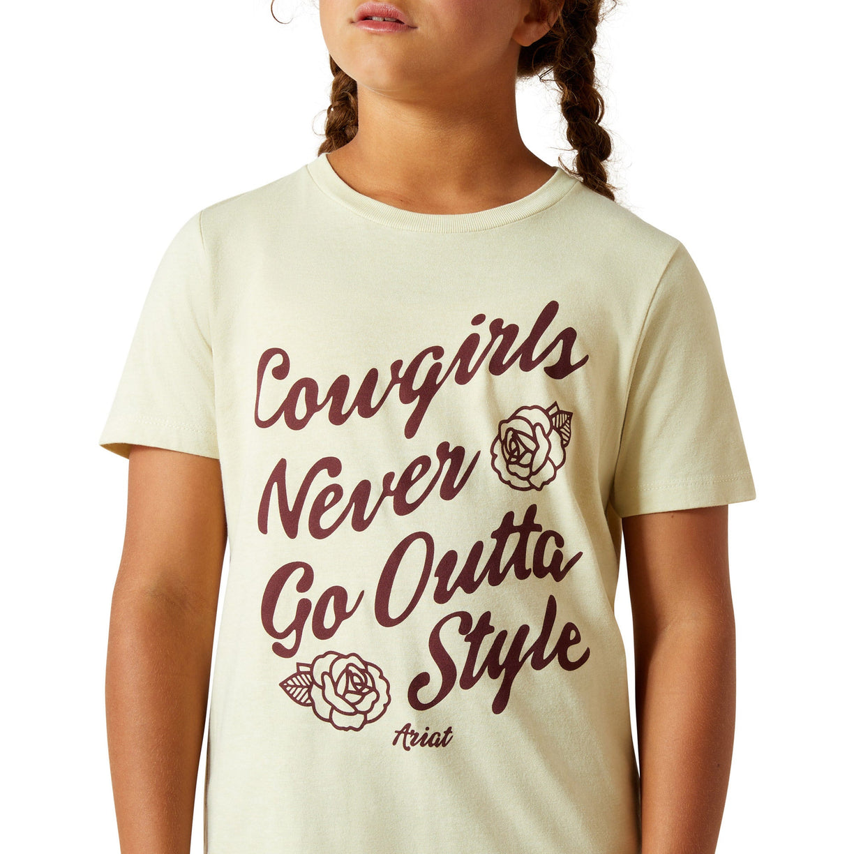 Child wearing a t-shirt with 'Cowgirls Never Go Outta Style' text and roses.