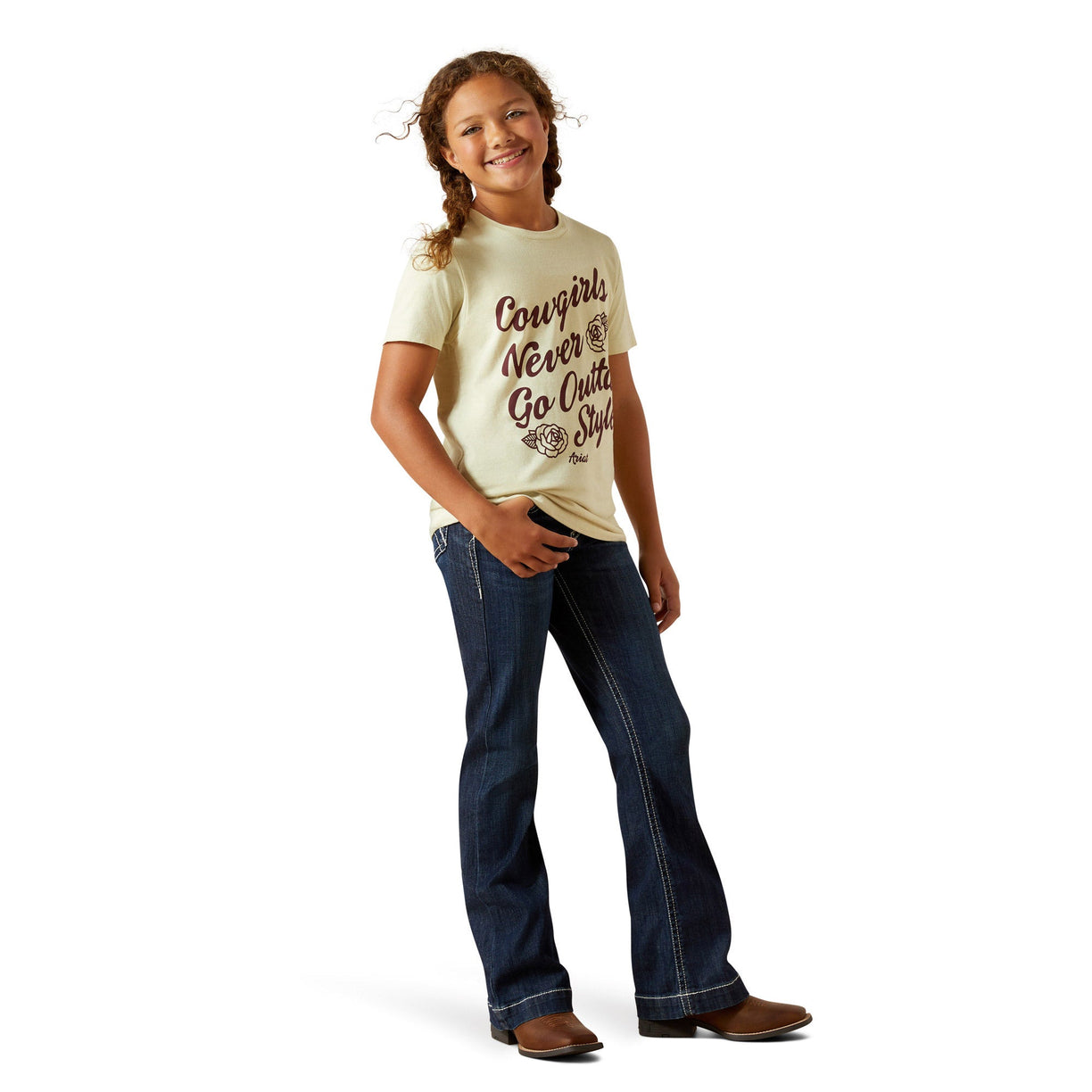Young girl wearing a 'Cowgirls Never Go Quietly' t-shirt and blue jeans on a white background