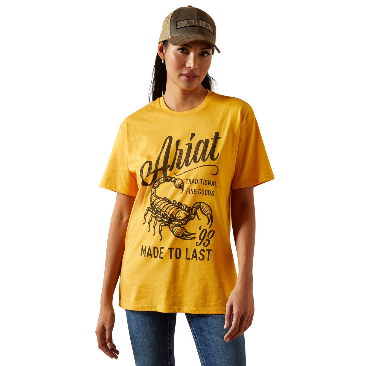Woman wearing a yellow Ariat t-shirt with branding on a white background