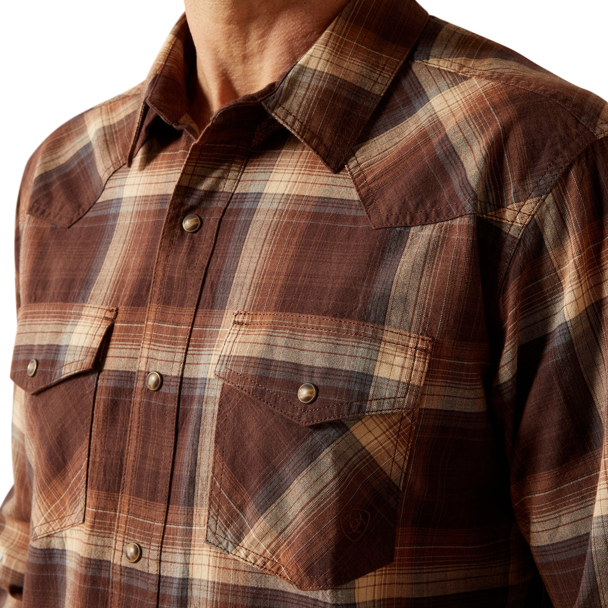 Close-up of a brown plaid shirt with buttons on a white background