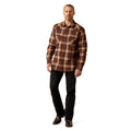 Man wearing a brown plaid shirt and black pants on a white background