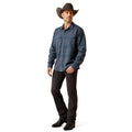 Man wearing a blue plaid shirt, black pants, and a cowboy hat on a white background