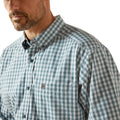 Man wearing a green and white checkered shirt with a brand logo on a white background