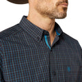 Man wearing a dark plaid shirt with a visible brand logo on a white background