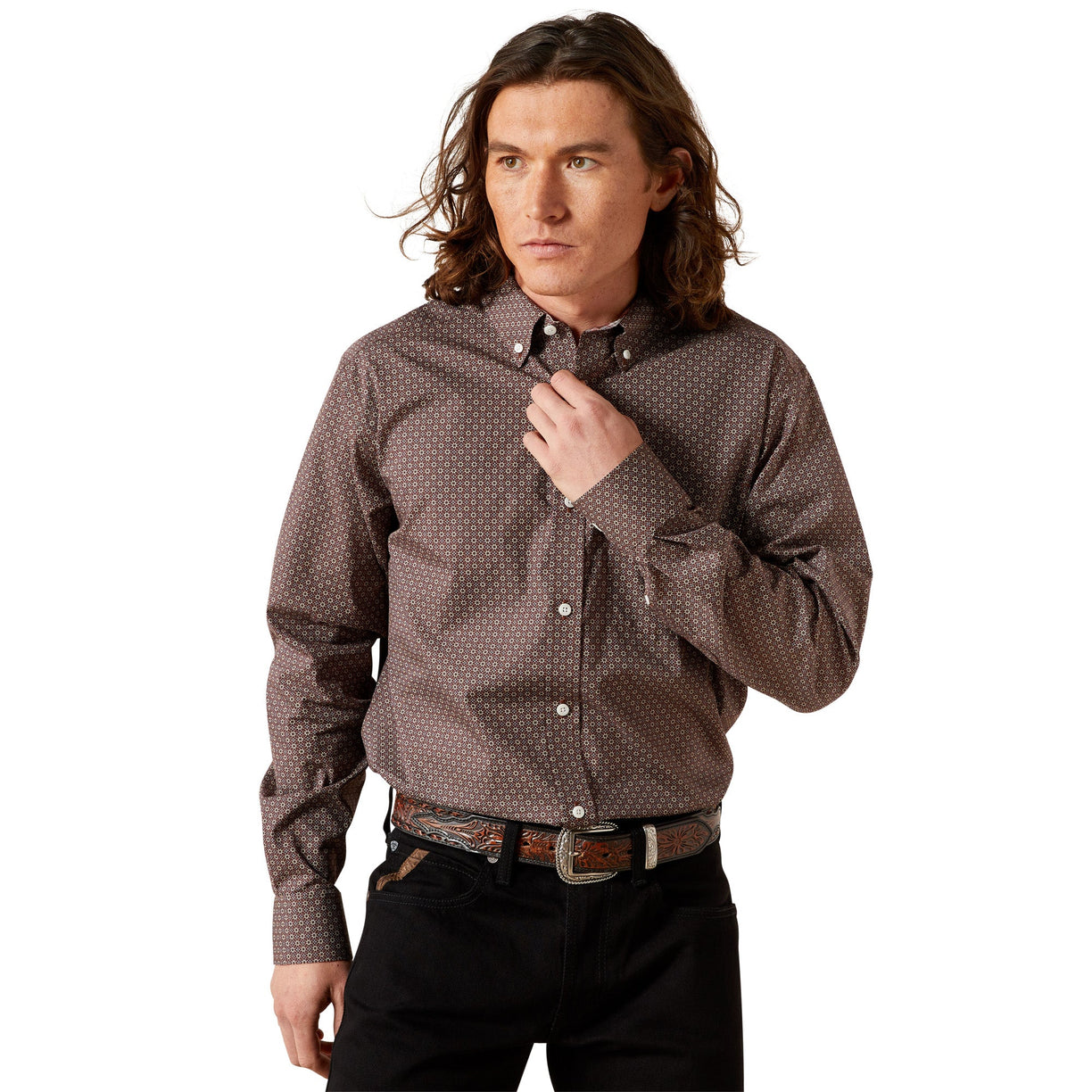 Man wearing a patterned shirt and black pants against a beige background