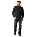 Man wearing a black patterned shirt and blue jeans on a white background