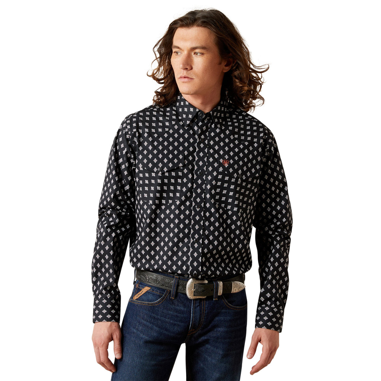 Man wearing a black patterned shirt and blue jeans on a white background