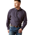 Man wearing a patterned shirt and jeans on a white background