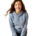 Girl wearing a gray hoodie with Ariat logo on a white background