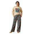 Woman wearing a beige sweatshirt with colorful graphic and patterned pants on a white background