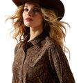 Woman wearing a brown patterned shirt and hat on a white background