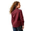 Woman wearing a maroon shirt and blue jeans on a white background